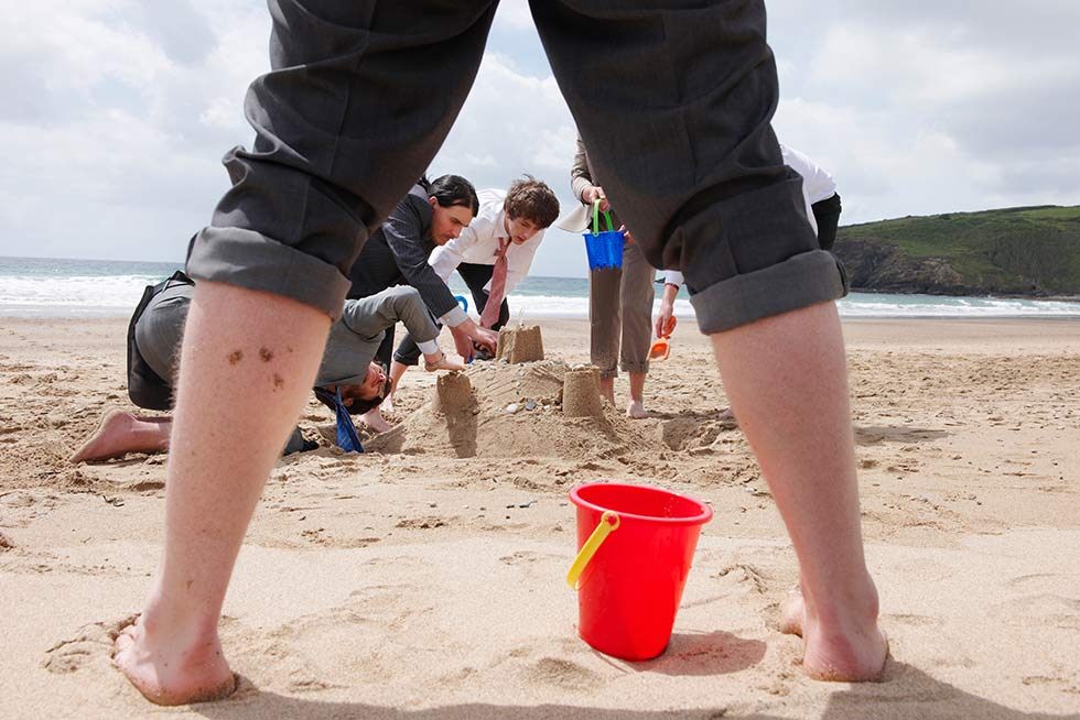 A group of people doing a sand castle team building activity