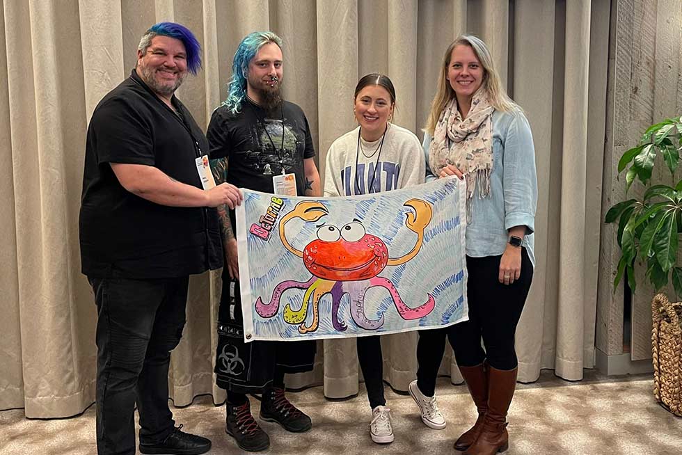 A group of people holding their flag for the Teamland Capture the Flag team building activity